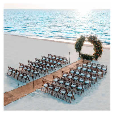 Setting up ceremony chairs on a tropical lawn